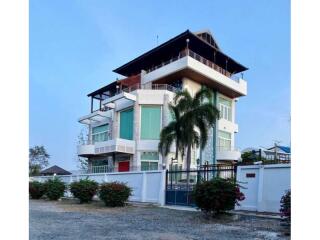 Modern multi-storey building with large windows and a palm tree