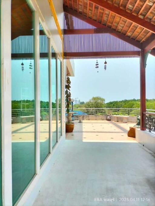 Spacious balcony with glass doors and wooden roof