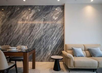 Modern living room with marble accent wall and dining area