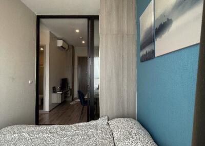 Modern bedroom with a large bed, blue accent wall, and wall art