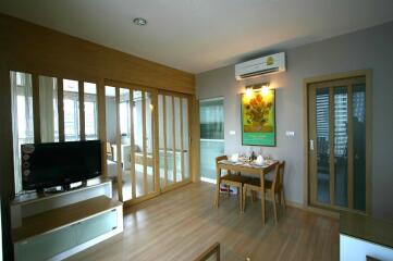 Modern living and dining area with TV, hardwood flooring, and air conditioning