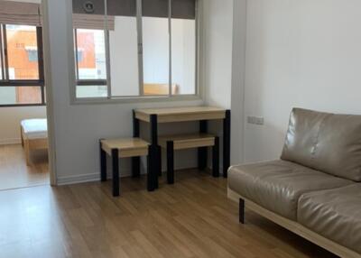 Living room with leather sofa and view into bedroom