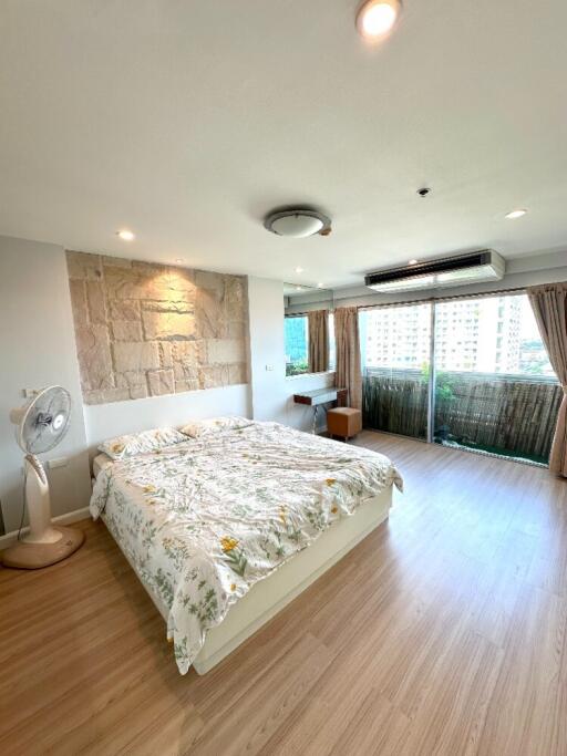 Spacious bedroom with large windows and wooden flooring