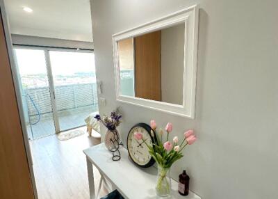 Well-lit hallway with decor and view of balcony