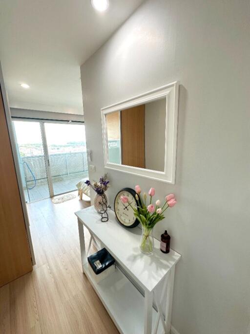 Well-lit hallway with decor and view of balcony