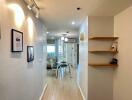 Bright hallway with light wooden flooring and decorative wall art leading to an open living area