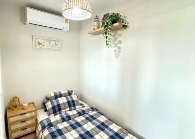 Cozy bedroom with bed, air conditioner, and wall shelf