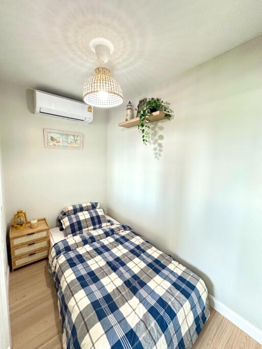 Cozy bedroom with bed, air conditioner, and wall shelf