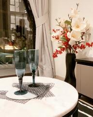 Living room with a table, glasses, and decorative vase