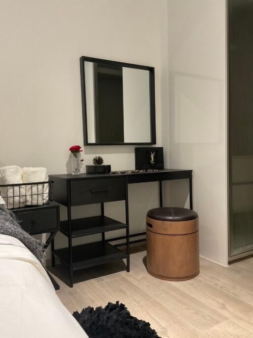 Bedroom vanity area with a mirror and stool