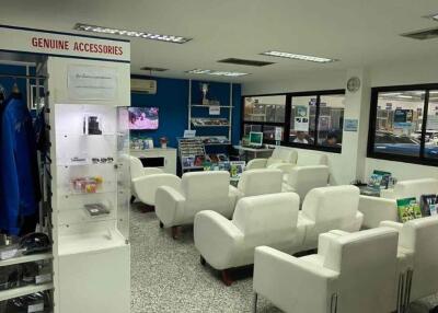 Waiting area with white chairs and accessory display