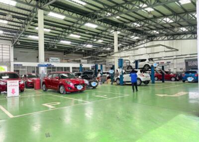 Indoor car maintenance facility with cars and mechanics