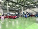 Indoor car maintenance facility with cars and mechanics