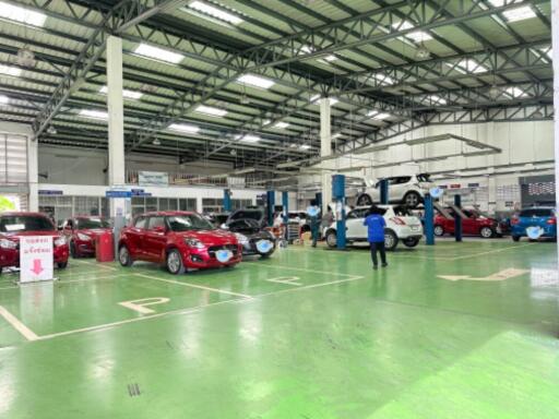 Indoor car maintenance facility with cars and mechanics