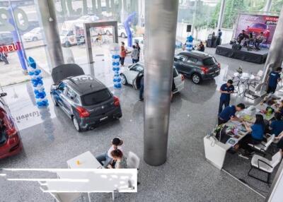 Car dealership showroom with multiple vehicles and staff