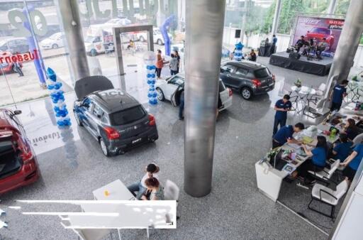 Car dealership showroom with multiple vehicles and staff