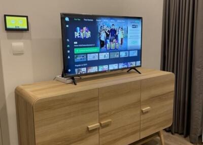 Modern living room with wooden TV cabinet and wall-mounted television