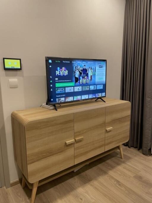 Modern living room with wooden TV cabinet and wall-mounted television