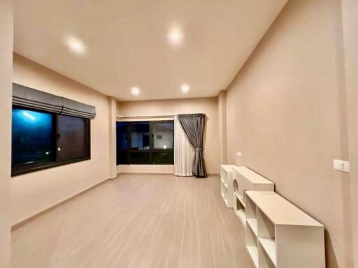 spacious living room with large windows and built-in shelving