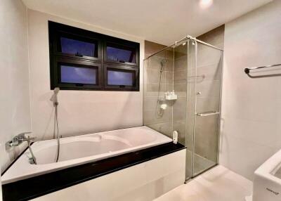 Modern bathroom with bathtub and glass-enclosed shower