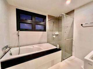 Modern bathroom with bathtub and glass-enclosed shower