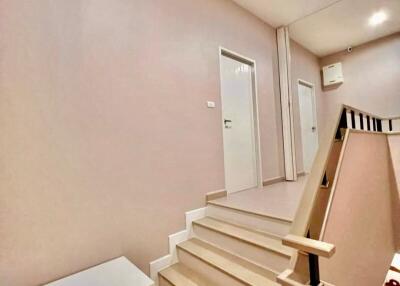 Staircase leading to upstairs hallway with white bench