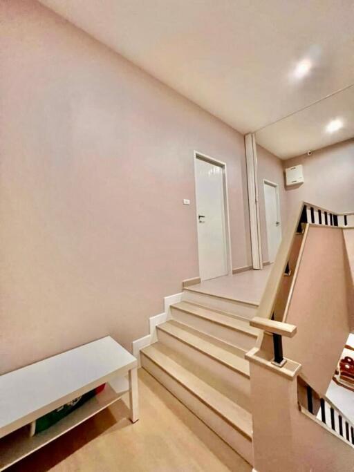 Staircase leading to upstairs hallway with white bench