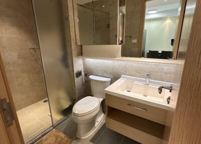 Modern bathroom with glass shower, toilet, and vanity