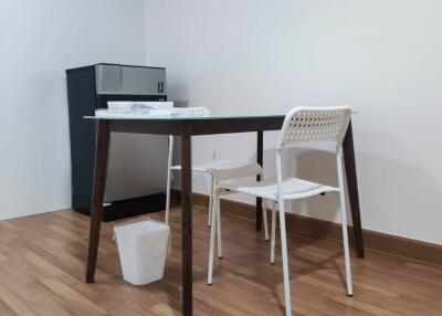 Minimalist kitchen area with small dining table and chairs