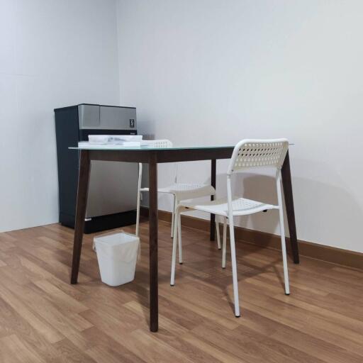 Minimalist kitchen area with small dining table and chairs