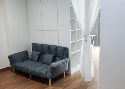 Living area with grey sofa and wooden flooring