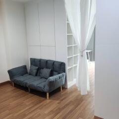 Living area with grey sofa and wooden flooring