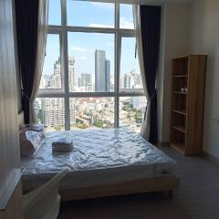 Modern bedroom with large windows and view of city skyline