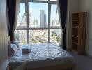 Modern bedroom with large windows and view of city skyline