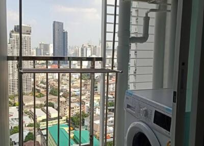 Laundry area with a washing machine and a city view