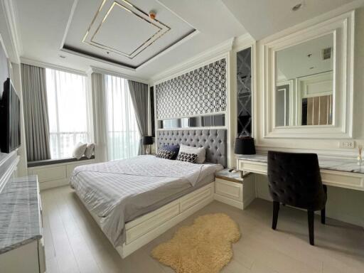 Modern bedroom with large windows, bed, desk and seating area