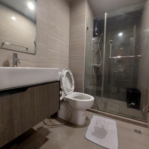 Modern bathroom with sink, toilet, and glass shower