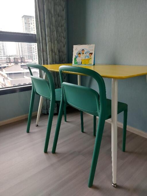 Small table with two chairs near a window in a room