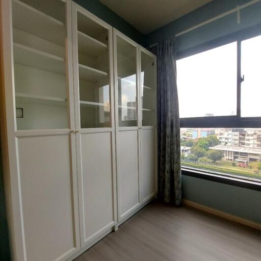 Bedroom with white storage cabinets and a large window