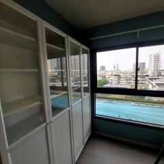 Room with large white cabinets and a view of the city through a window