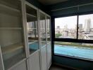 Room with large white cabinets and a view of the city through a window