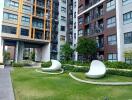 Exterior view of modern high-rise residential buildings with landscaped greenery and unique outdoor seating.