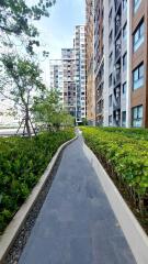 Walkway next to high-rise buildings with greenery