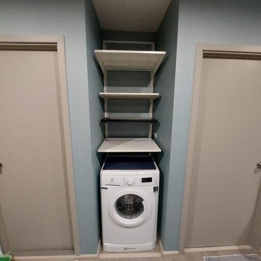 Laundry area with washer and shelving