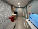 Modern living space with TV, couch, and kitchenette