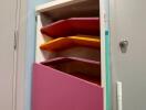 Colorful wall-mounted storage cabinet with cleaning tools