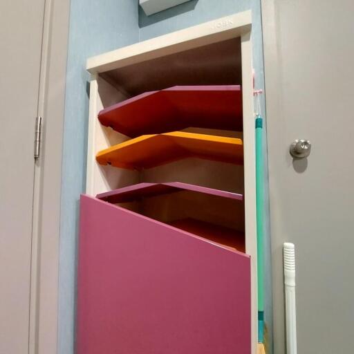 Colorful wall-mounted storage cabinet with cleaning tools