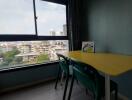 room with window view and yellow table