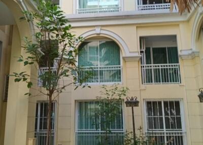 Exterior view of a building with balconies and a small garden