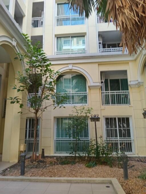 Exterior view of a building with balconies and a small garden